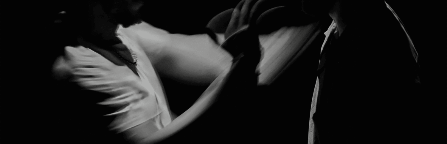 Photo en noir et blanc des deux artistes en mouvement.