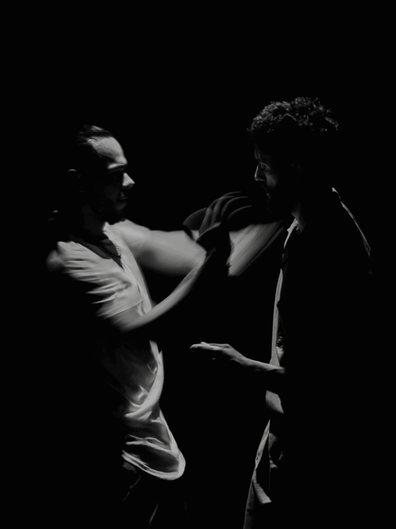 Photo en noir et blanc des deux artistes en mouvement.