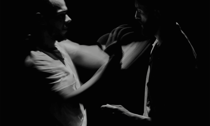 Photo en noir et blanc des deux artistes en mouvement.