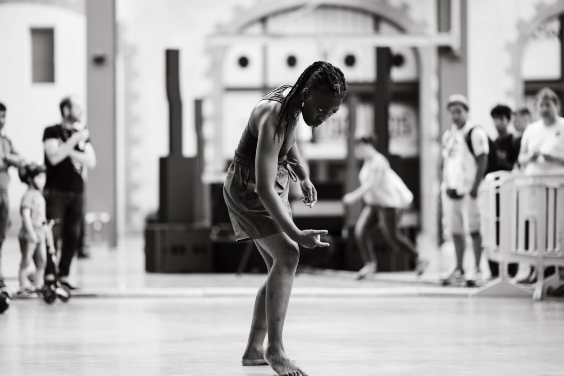 Photo en noir et blanc. Linda dansant au centre.