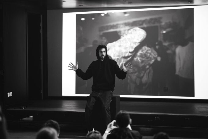 Photo en noir et blanc de l'artiste Timothée LeJolivet, en pleine prise de parole.