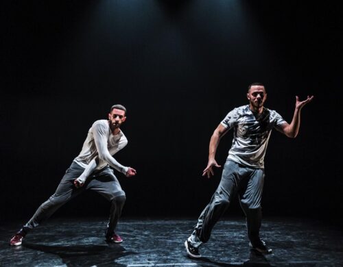 Deux danseurs en mouvement avec fond noir au spectacle Dans l'arène.