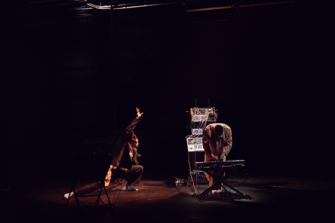 Un danseur en mouvement faisant face à un musicien jouant sur un piano électrique pour le spectacle Earthbound.