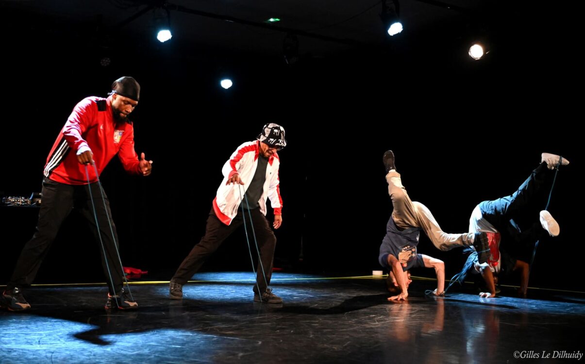 Danseurs en mouvement sur scène durant la performance J-2.