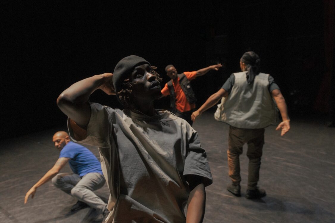 Danseurs en mouvement, un en premier plan et les autres derrière.