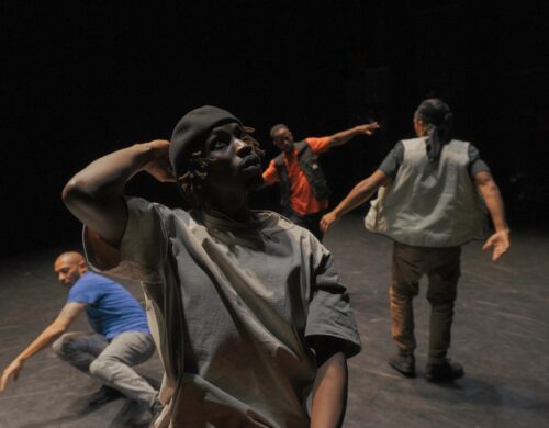 Danseurs en mouvement, un en premier plan et les autres derrière.