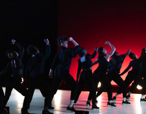 Danseuses sur scène, en mouvement. Le fond est rouge et elles sont en noir.