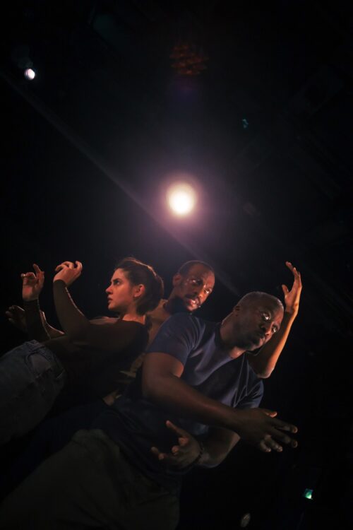 Trois danseurs en mouvement en contreplongée lors du spectacle Recovering.