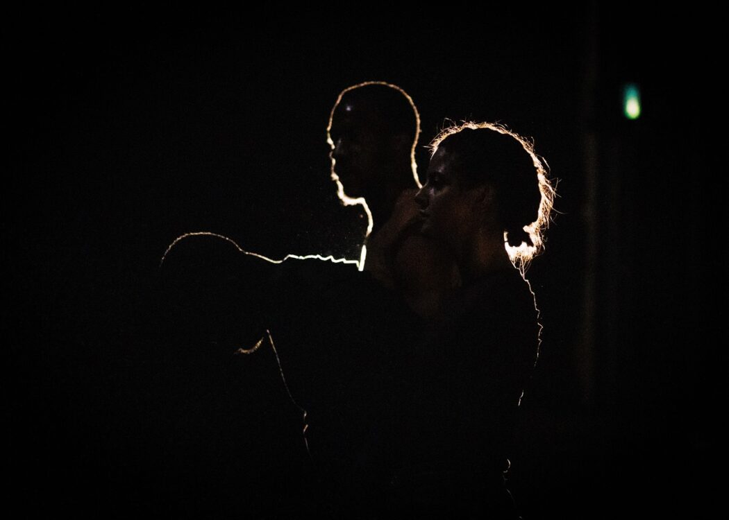 Trois danseurs dans un décor sombre pour le spectacle Recovering.