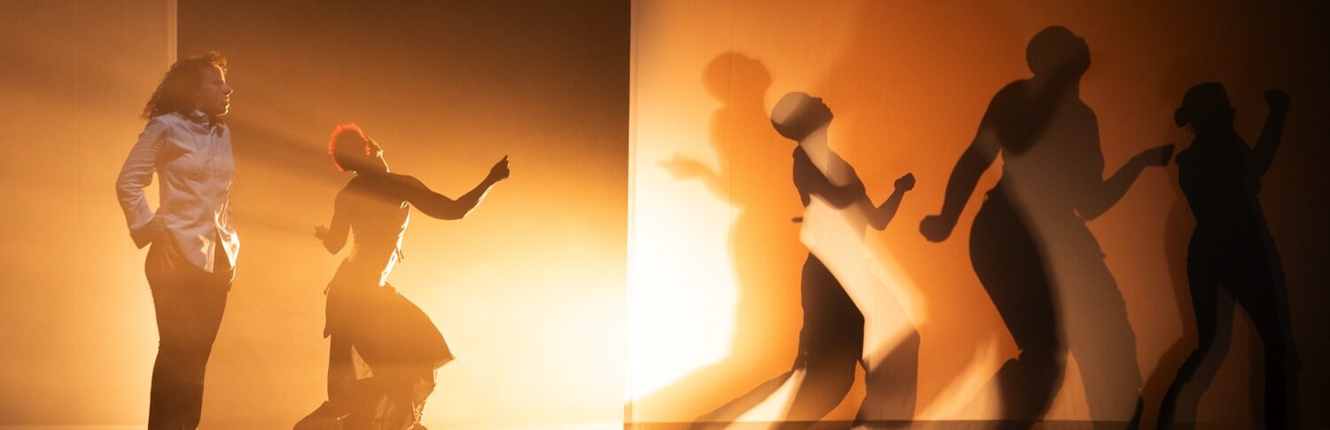 Danseuses en mouvement, jeu d'ombre et de lumière jaune.