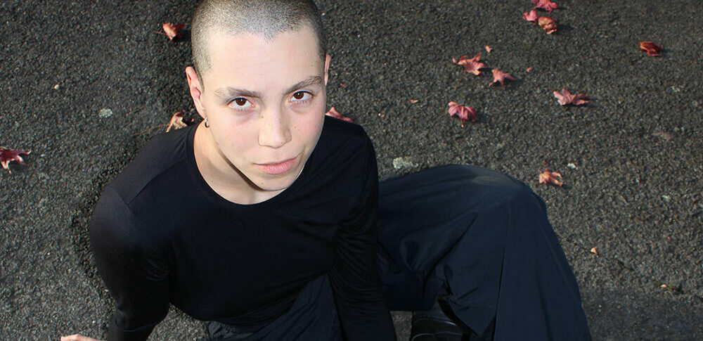 Photo portrait de l'artiste Suzanne Degennaro. L'artiste est au sol et regarde vers la caméra.